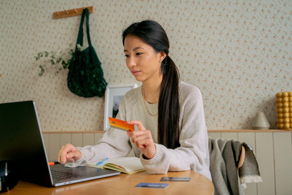 Woman at laptop with credit card shopping online