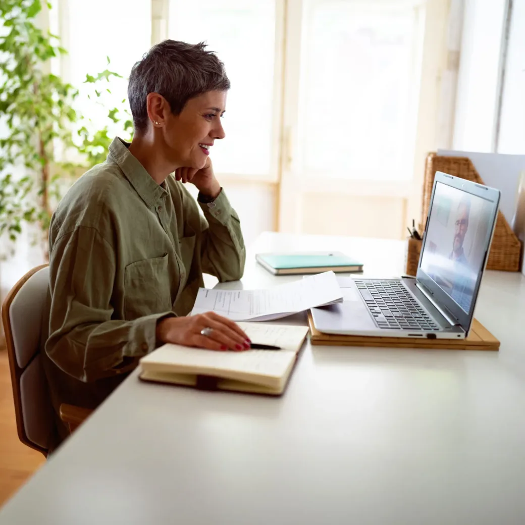 Woman following online courses on her laptop at home.