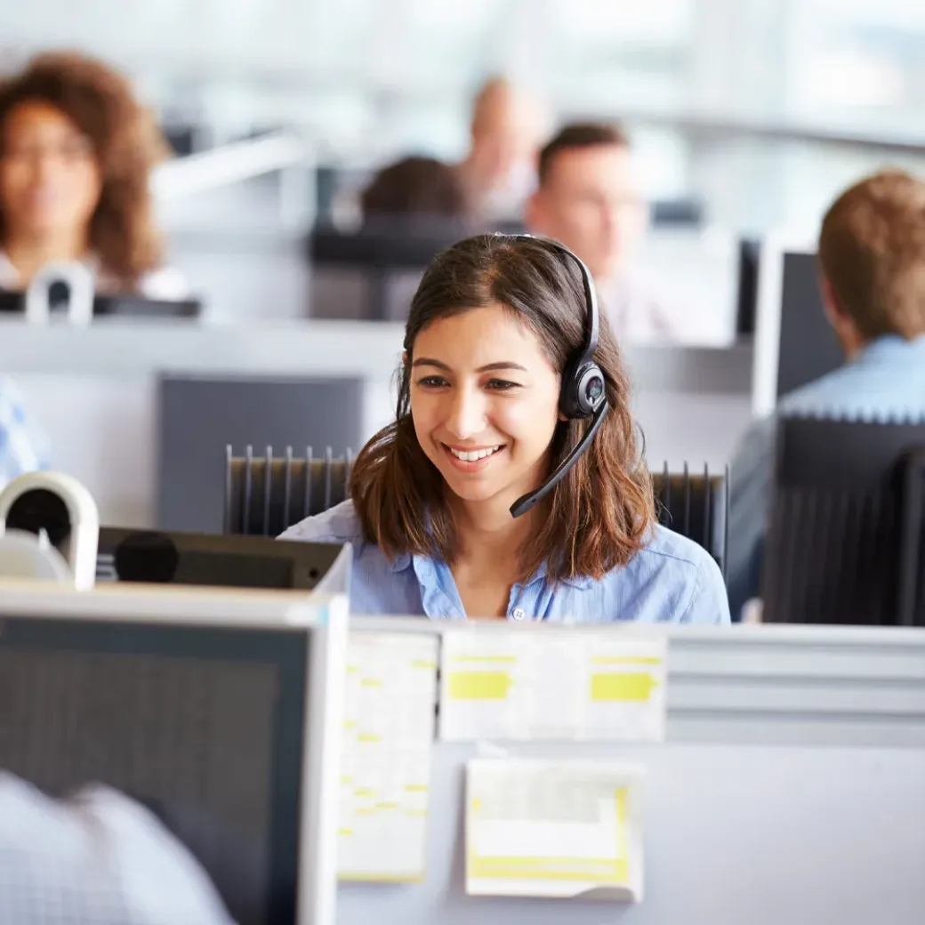Young woman working in call center, surrounded by colleagues